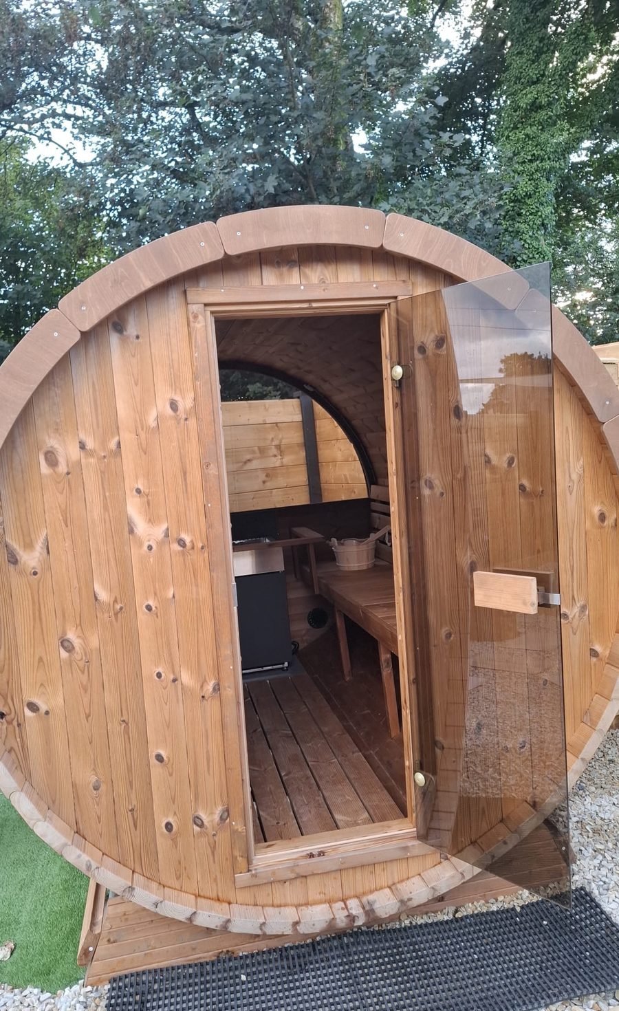 Barrel sauna exterior with door open at B & M Saunas